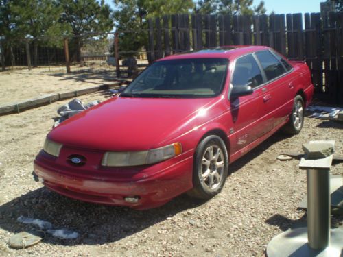 1995 red taurus sho plus a green parts car